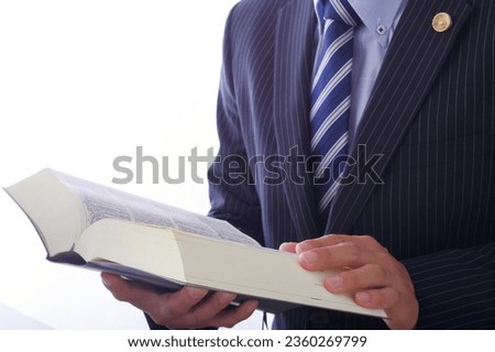 A male lawyer who reads all the six laws.

On the cover of the book, it is written as "Rokuho Zensho" in Japanese. Royalty-Free Stock Photo #2360269799