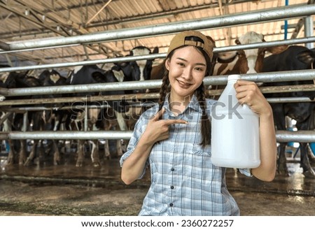 Young cow girl holding plastic milk container in dairy farming, animal husbandry concept