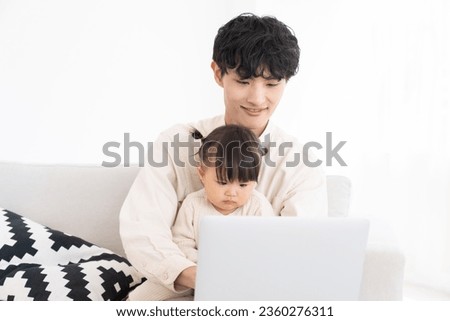 portrait of asian dad and daughter , laptop