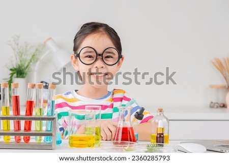 little girl Wear a brightly colored shirt working with test tube science experiment in white room
