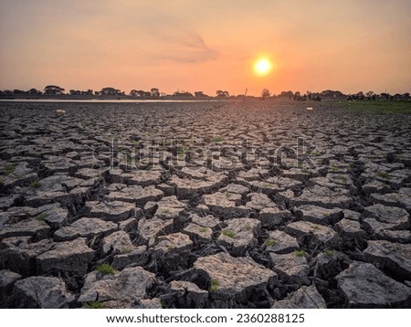 Natural view of cracked soil from reservoir that has dried up due to long drought with sunset in the background,location in Mulur reservoir,Sukoharjo,Indonesia.