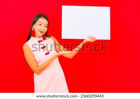 Portrait beautiful young asian woman show white empty billboard on red background