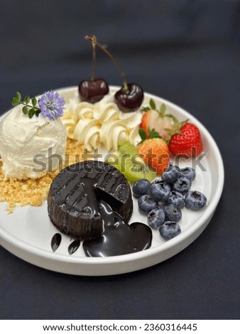 Mixed berry french toast with whip cream, mint, dark chocolate lava and yellow flower on a white dishes. Black background, Strawberry, Blueberry, Cherry, Shine Muscat. Picture free space for text