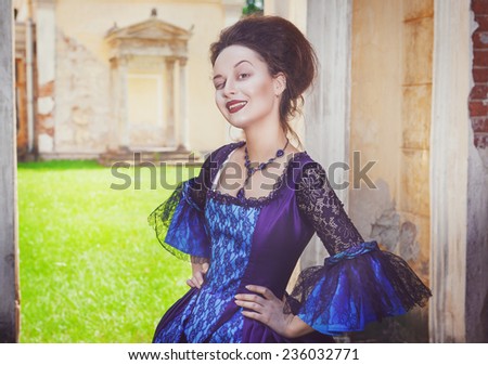 Beautiful woman in blue medieval dress winking 