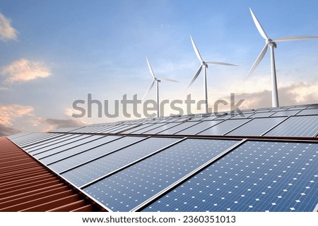 Solar panel on factory roof with wind turbine and blue sky background