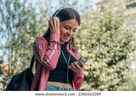 student girl with headphones outside campus
