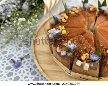 Chiffon cake thai taro custard with fresh taro and yellow flower toping on wooden plate. Traditional Thai Desserts. Bakery picture free space for text. Cafe and coffee shop menu.
