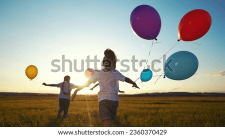 children in balloons in park. children run in nature in park with balloons. happy family kid holiday concept. children view from back silhouette run in nature at dream sunset holding balloons