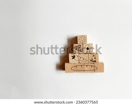 Basic food pyramid on wooden cube isolated on white background. Template signs for healthy eating diet concept