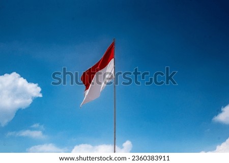 Indonesia flag on the mast in blue sky, The Red and white Flag, national symbol of Indonesia.