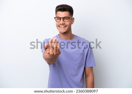 Young caucasian man isolated on white background inviting to come with hand. Happy that you came Royalty-Free Stock Photo #2360388097