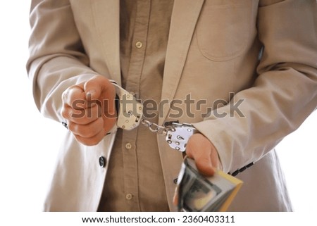 Hands of a fraudster with handcuffs on a background of us dollars and credit cards. Fraud, cyber crime concept. credit card fraud. Arrest of an entrepreneur in the workplace.