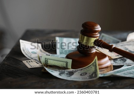 judge gavel and money on brown wooden table  Royalty-Free Stock Photo #2360403781