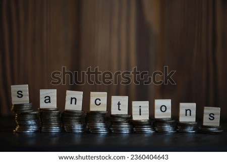 Word Sanctions made of wooden block letters with dramatic lighting and bokeh