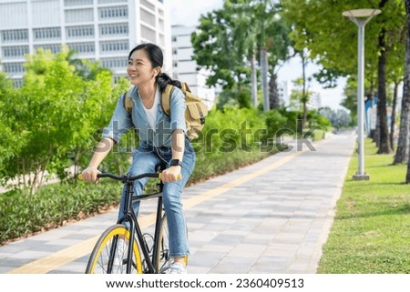 Asian woman riding a bicycle in the park.