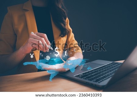 Businesswoman hand holding virtual world with international currency include dollar yuan yen euro and pound sterling sign. Concept of global currency exchange, money transfer and forex by technology. Royalty-Free Stock Photo #2360410393