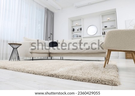 Fluffy carpet and stylish furniture on floor indoors, low angle view Royalty-Free Stock Photo #2360429055