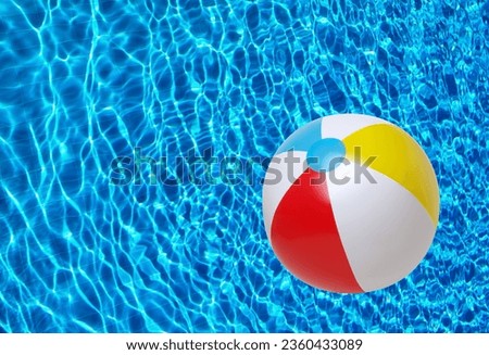Swimming pool water surface background and beach ball