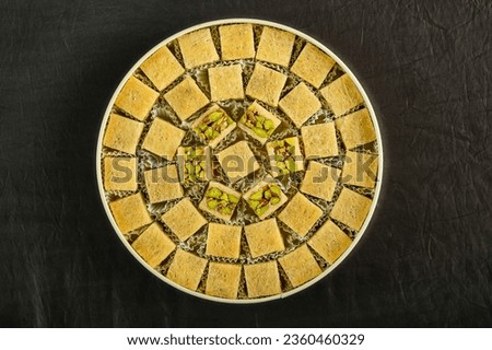 Arabic sweets boxes. Pictured from above showing several shapes and types of sweets with sesame, pistachios, dates and walnuts.