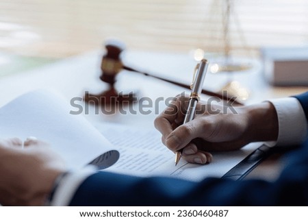 Lawyer leafing through documents and signing contract at work in office
