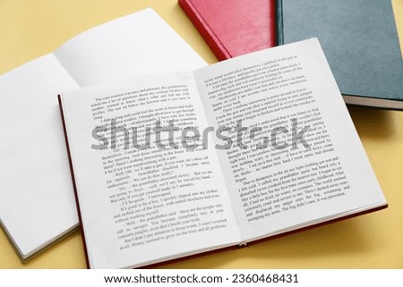 Open books on yellow background Royalty-Free Stock Photo #2360468431