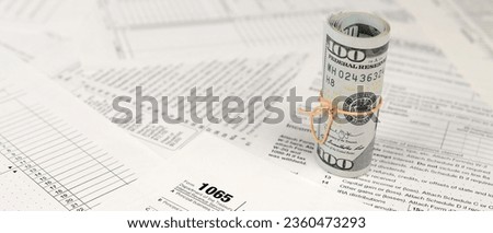 1065 U.S. Return of Parentship Income form with roll of american dollar banknotes close up. Concept of tax period in United States Royalty-Free Stock Photo #2360473293