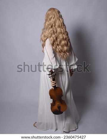 Full length portrait of blonde woman  wearing  white historical bridal gown fantasy costume dress. Standing pose, facing backwards walking away from camera, isolated on studio background.