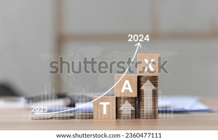 Interest Rates, Inflation and Taxes Place the wooden block on the coin with the Tax 2024 icon with an up arrow on the coin. investment concept and interest rate Financial and statistical graph Royalty-Free Stock Photo #2360477111