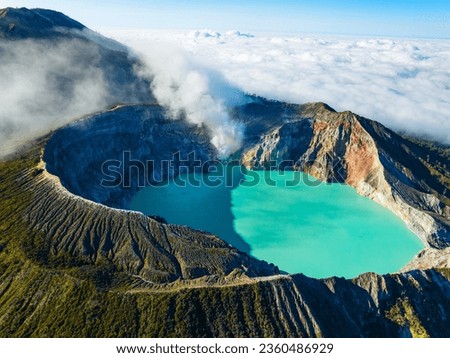 Aerial view of rock cliff at Kawah Ijen volcano with turquoise sulfur water lake at sunrise.Amazing nature landscape view at East Java, Indonesia. Natural landscape background