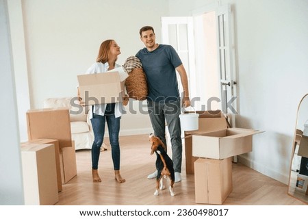 New home to live. Young couple with dog are moving to appartment.