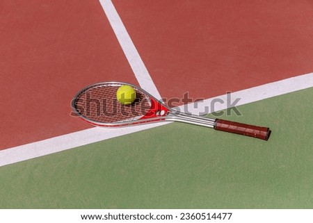Tennis racket and ball on a hard tennis court