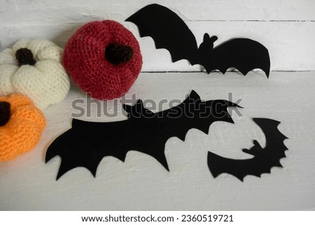 Halloween decorations. Black paper bats and knitted pumpkins. Handmade for Halloween.