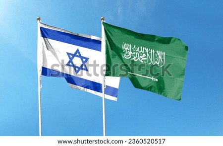 Israeli and Saudi Arabian flags flutter under cloudy skies. fly in the sky Royalty-Free Stock Photo #2360520517