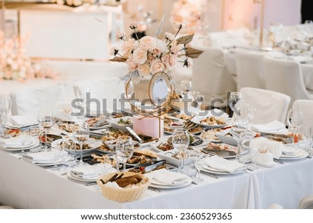 Wedding setup. Table setting serving. Banquet decoration in hall restaurant. Luxury reception. Festive table decorated composition flowers in party area. Golden geometric decorative sign number table.