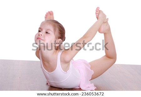 Smiling young girl doing gymnastics isolated over white