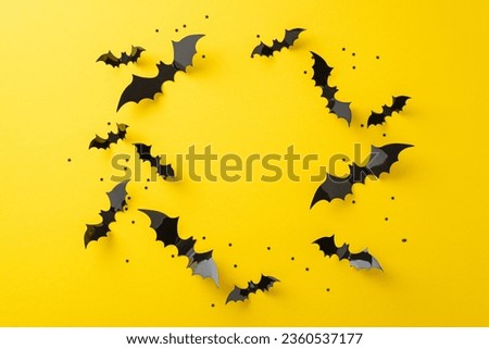 Experience the shivers of Halloween night frights. Above view picture showcasing a circle from black paper bats and confetti stars on yellow isolated surface, suitable for text or advertising placemen