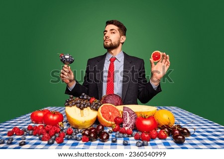 Taste. Man sitting at table against green background and eating fresh berries, fruits and vegetables. Concept of food, creativity, organic products, health. Pop art photography. Copy space for ad