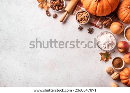 Autumn fall baking background with pumpkins, apples, nuts, food ingredients and seasonal spices on white, top view, copy space. Cooking pumpkin or apple pie for Thanksgiving and autumn holidays. Royalty-Free Stock Photo #2360547891