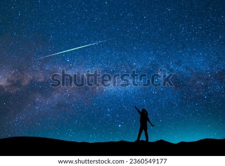Fantasy landscape, silhouette of a hiker standing on the hill, on the milky way galaxy background.