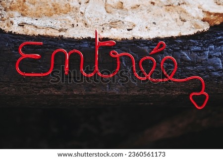 Front of an artisanal store with the word “Entrée” entry written in red in French