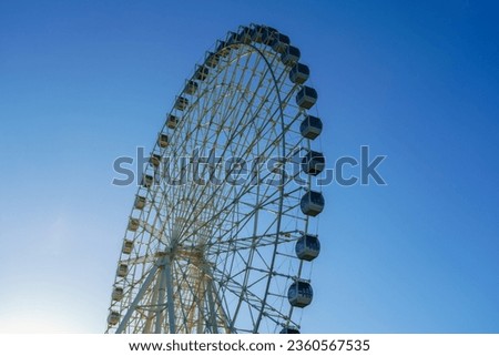 High ferris wheel at sunset or sunrise with blue sky background in an amusement park Navruz in Tashkent, Uzbekistan.