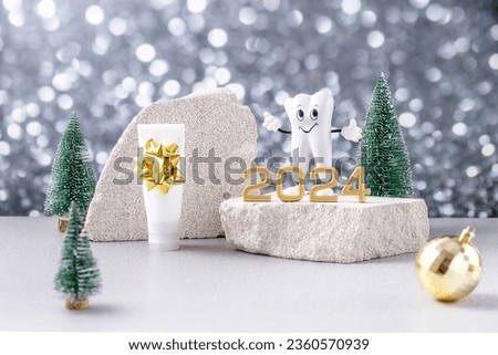 cartoon model of a tooth, the numbers 2024 on a podium made of stone, toothpaste and Christmas trees on a background of silver bokeh
