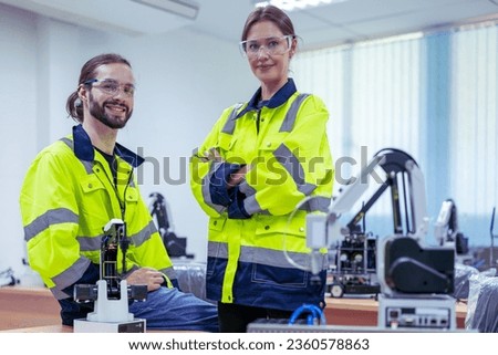 Female and male electronic  engineers in AI Robot, robot arm in the manufacturing automation and transportation robotics. Robotics, Robot for industry. Collaborative robot, safe, flexible. AI