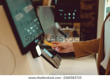 Woman pays at self-checkouts in supermarket. Royalty-Free Stock Photo #2360583725