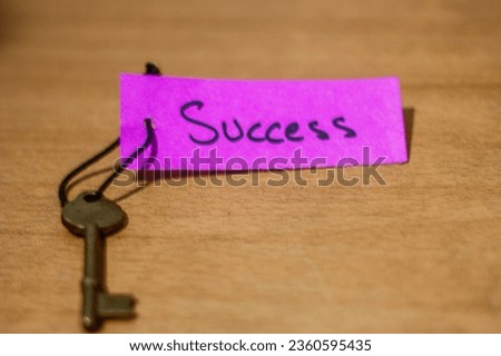 concept for a happy successful life using an old decorative key and a hand written tag attached by a black cord. Success, successful life, key to success, positivity, positive mentality, message 