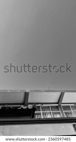Background showing the roof side of the building taken against a clear blue sky with a horizontal flat direction. visible windows on the upper side of the building. photo copy space and isolated.