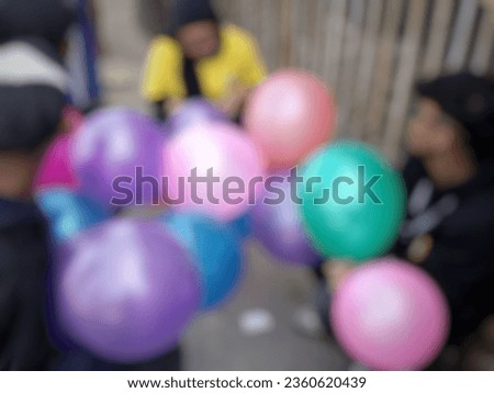 Blurred image of Birthday balloons Holding by happy man at summer carnival. Colorful colorful balloons floating in Happy New Year Party, birthday balloons concept