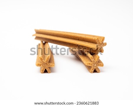 Dog chewing sticks on a white background. Treats for dogs. Royalty-Free Stock Photo #2360621883