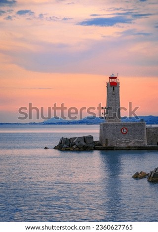 Stunning view of the Mediterranean Sea with the lighthouse in the harbor at sunset in Nice, South of France or the French Riviera Royalty-Free Stock Photo #2360627765