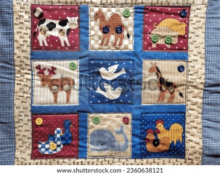 Close-up of a handmade quilt with animal patterns and buttons